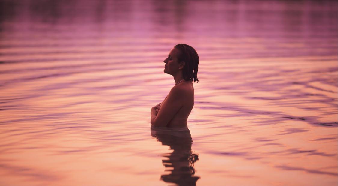 Una figura nell’acqua al tramonto.